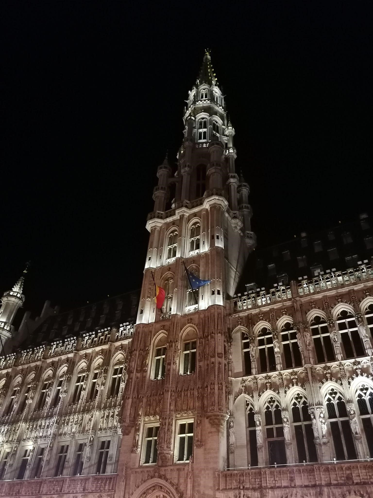 The Belgian flag and the flag of the European Union waving from the town hall at Grand Place, Brussels.